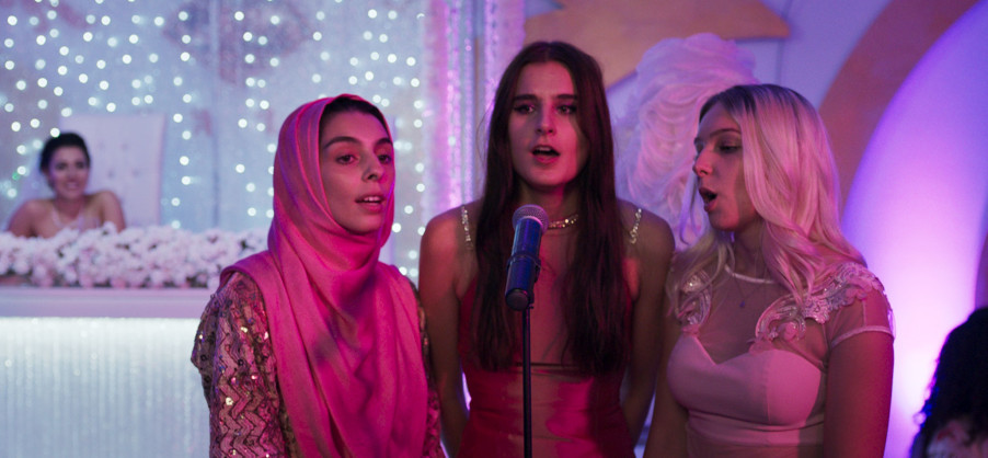 Drei junge Frauen singen vor einem Mikrofon