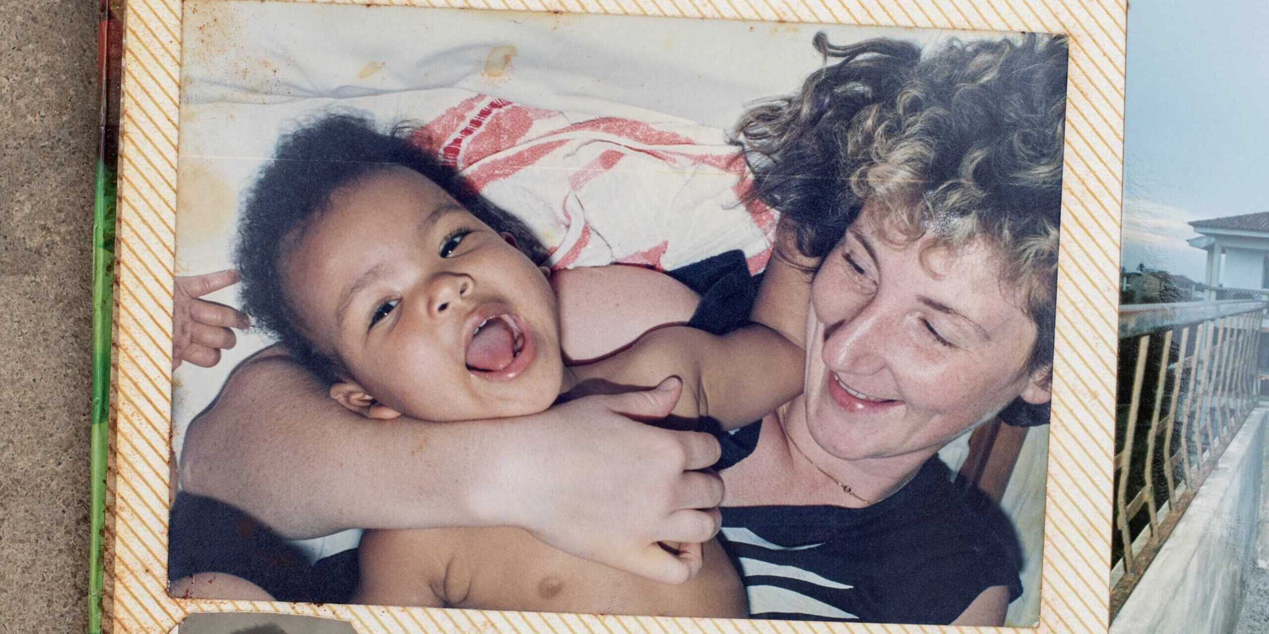 Ein Foto in einem Fotoalbum, auf dem eine Frau ein Baby im Arm hält